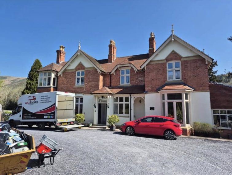 Apex Removals van being loaded with a ramp outside a large Victorian country house